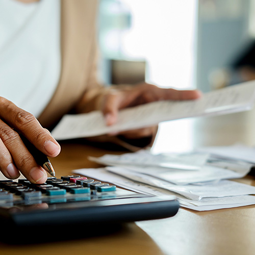 Woman Using Calculator To Calculate bills