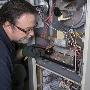 technician repairing gas furnace